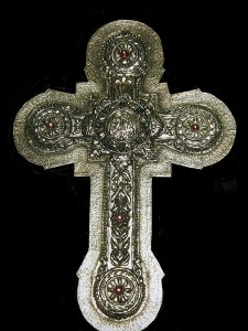 Cruz. Repujada y mateada en metal con piedras incrustadas.
